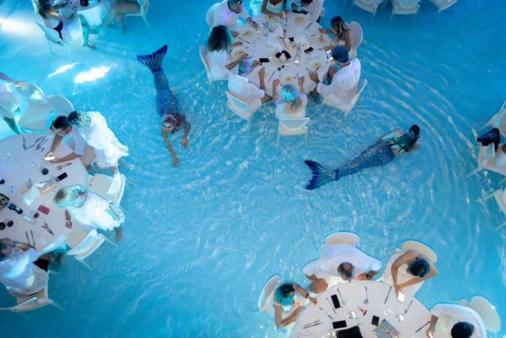 Jantar dentro de piscina com ‘sereia’ entre mesas viraliza e rende piadas no Brasil; conheça
